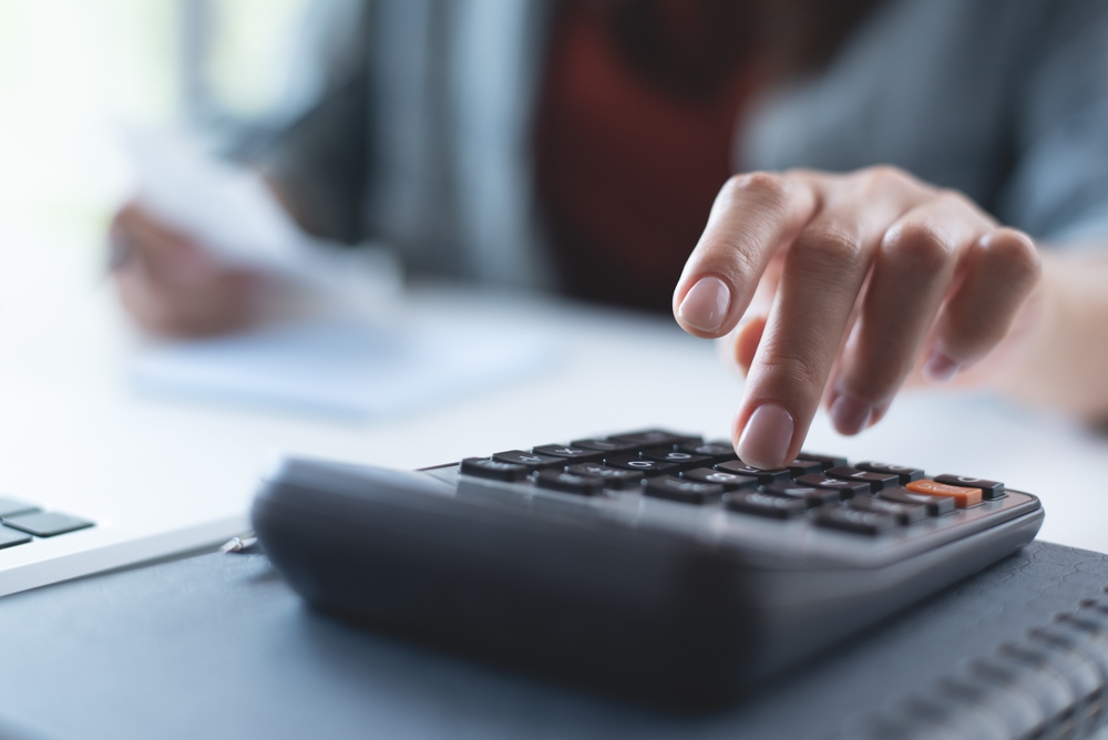 person doing monthly accounting on a calculator